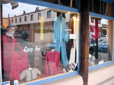 The Crazy Fox shop window on Don Gaspar Avenue with dresses on display