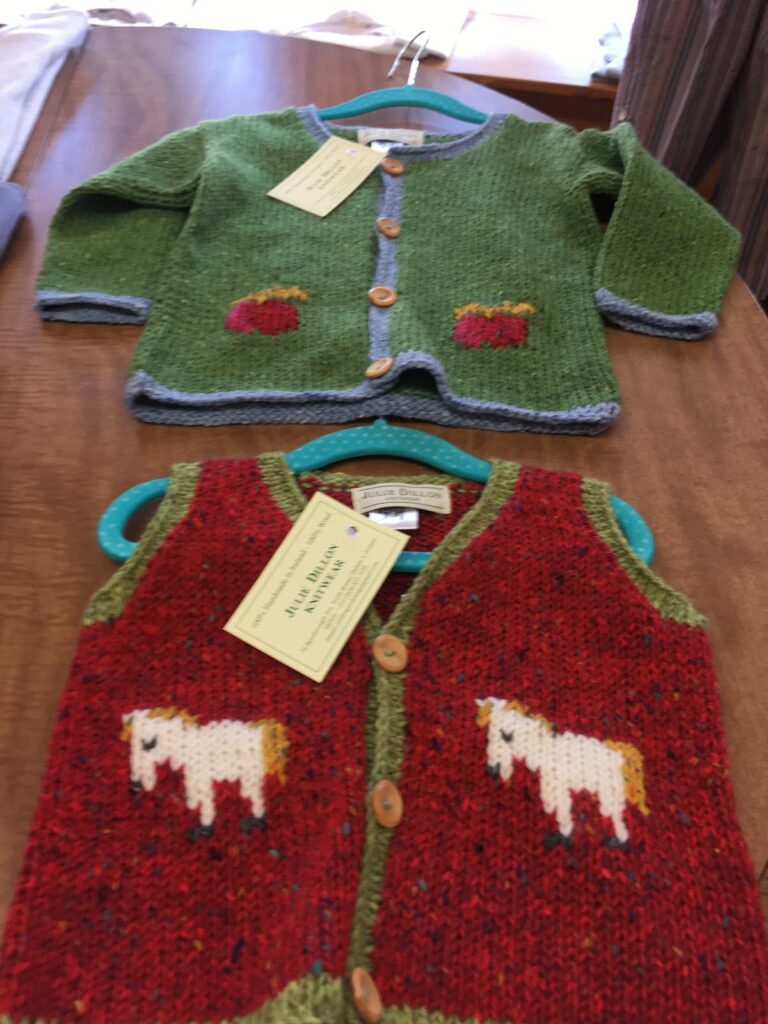 Green and red hand knit children's cardigans with sheep and cow motifs