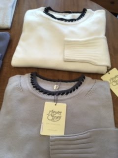 Stack of cream and grey knit sweaters