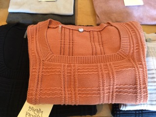 Folded rust coloured ribbed knit top with a Crazy Fox price tag